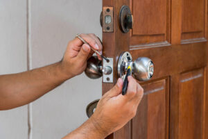 Locksmith repairing a doorknob lock.